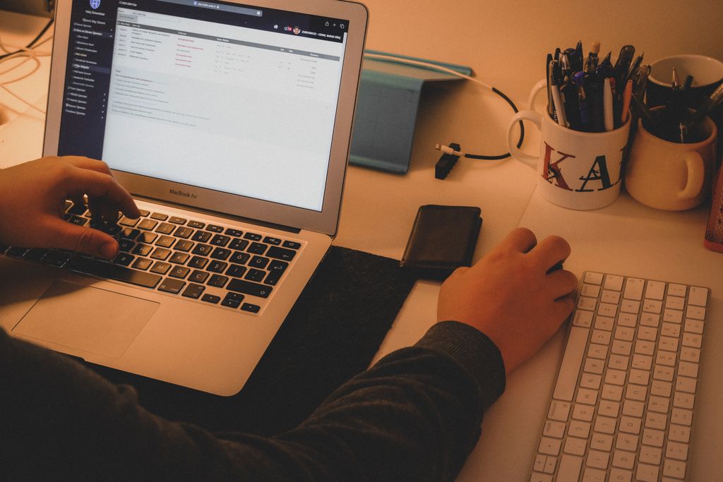 A person engaged in multitasking with a laptop and keyboard at a workspace in İstanbul.